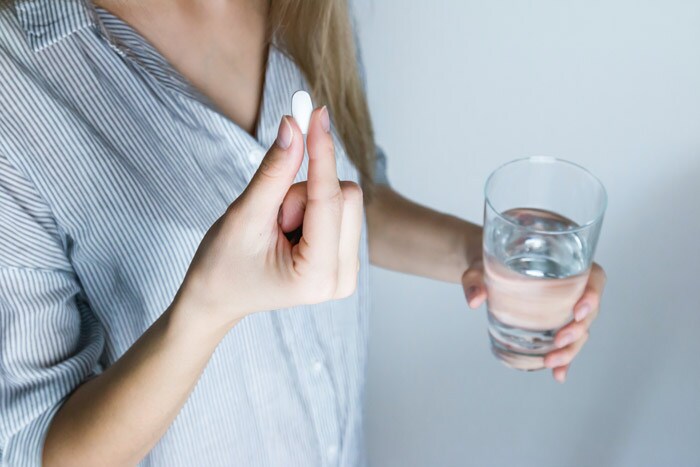 Title Mujer tomando antiinflamatorio como tratamiento de la dismenorrea