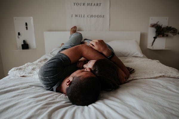 Title Pareja abrazándose en la cama