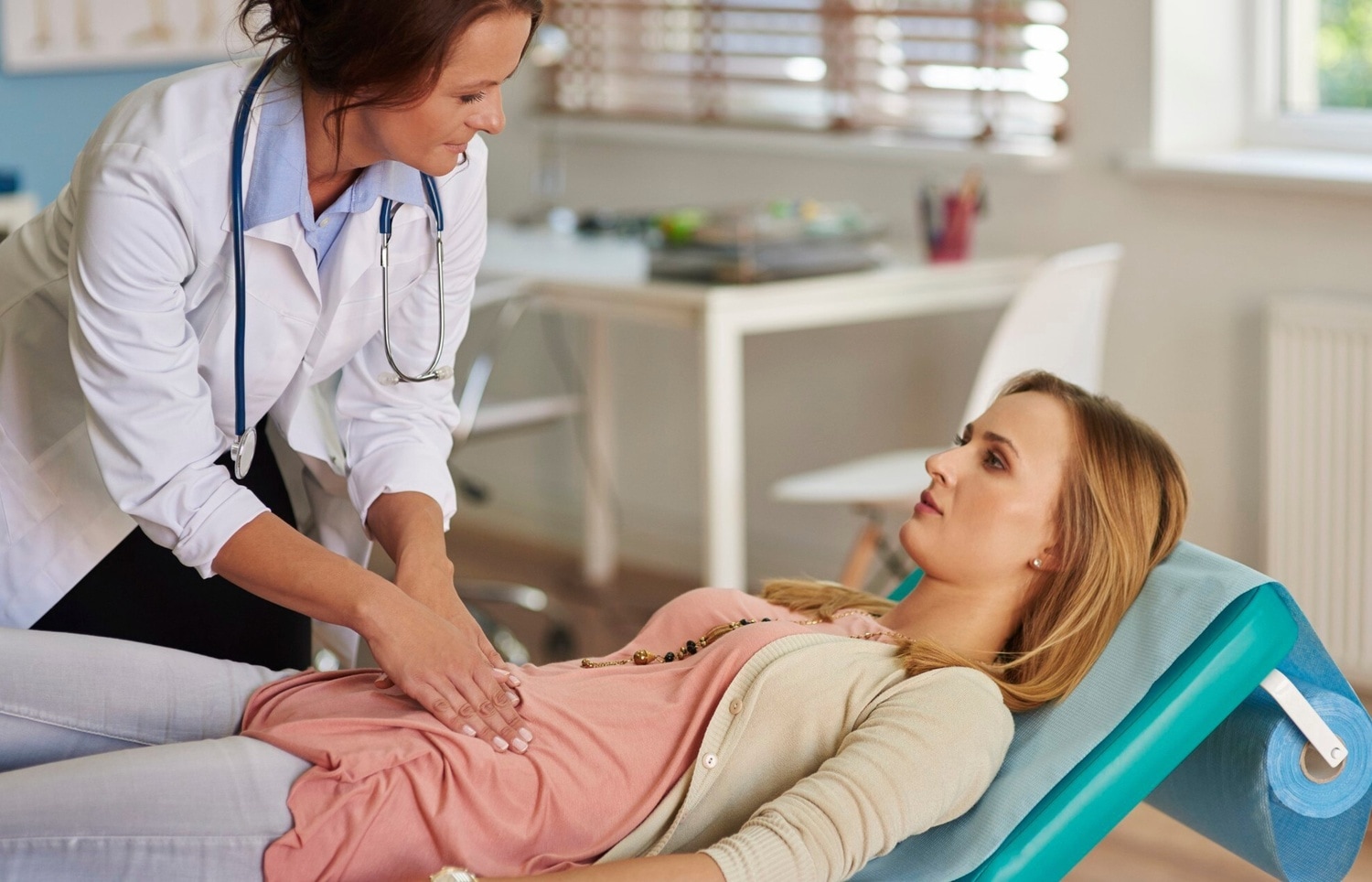 Mujer en el médico comprobando dolor abdominal