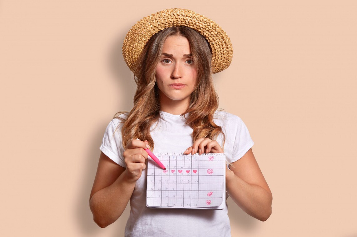 Mujer señalando su calendario de menstruación